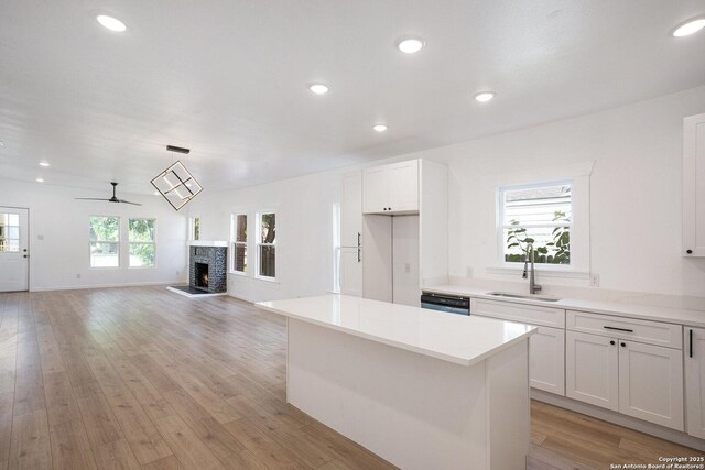 1645 W Magnolia Ave, San Antonio, TX 78201 - kitchen featuring a sink, a fireplace, a kitchen island, light countertops, and recessed lighting