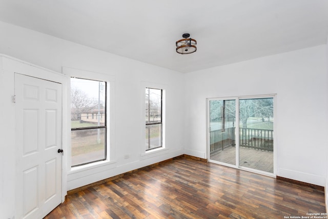 unfurnished room featuring a healthy amount of sunlight and dark hardwood / wood-style flooring