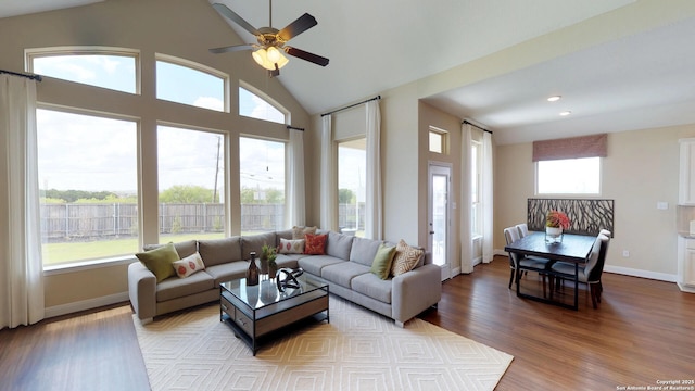 living room featuring ceiling fan, high vaulted ceiling, and light hardwood / wood-style floors