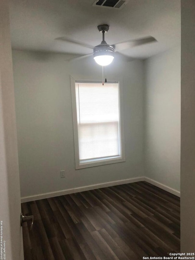 spare room with ceiling fan and dark hardwood / wood-style floors