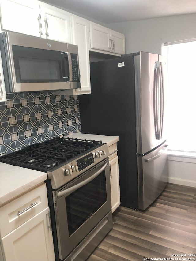 kitchen with white cabinetry, backsplash, appliances with stainless steel finishes, and dark hardwood / wood-style flooring