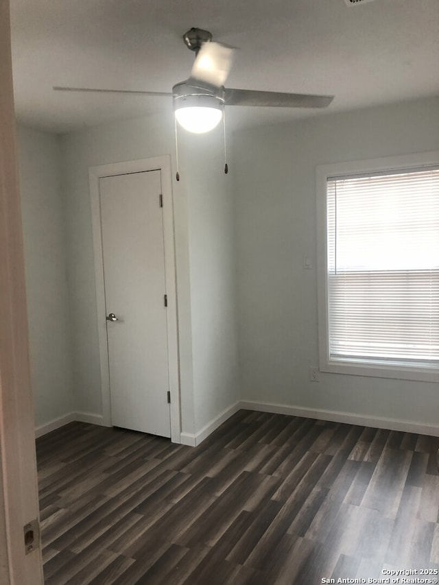 spare room featuring dark wood-type flooring and ceiling fan