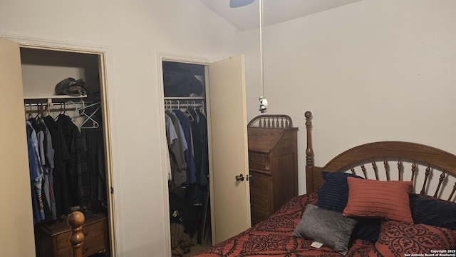 bedroom featuring lofted ceiling and two closets