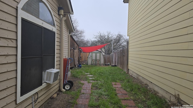 view of yard with an outbuilding, fence, and a storage shed