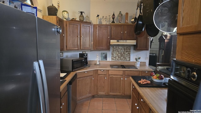 kitchen with light tile patterned floors, black appliances, light countertops, and under cabinet range hood