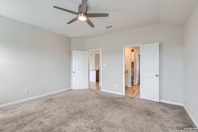 unfurnished bedroom with light carpet, baseboards, visible vents, and lofted ceiling