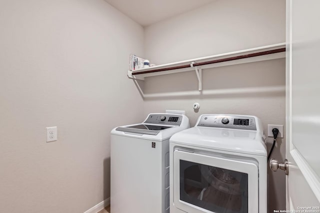 laundry room with laundry area, washer and clothes dryer, and baseboards