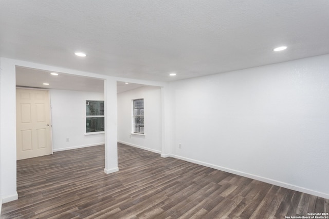 basement featuring a textured ceiling and dark hardwood / wood-style flooring