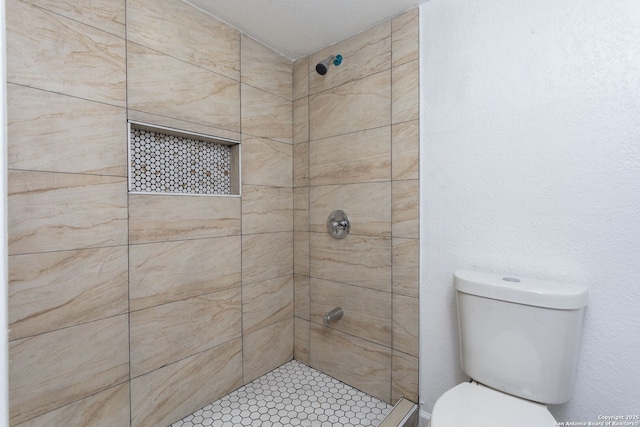 bathroom with tiled shower and toilet