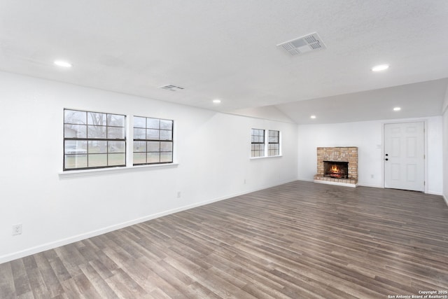 unfurnished living room with a fireplace, vaulted ceiling, and hardwood / wood-style floors