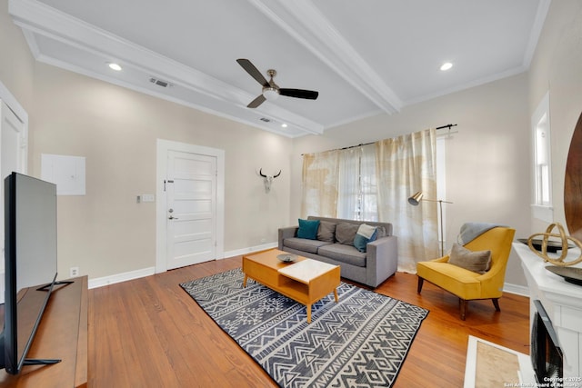 living area featuring beam ceiling, visible vents, ornamental molding, wood finished floors, and baseboards