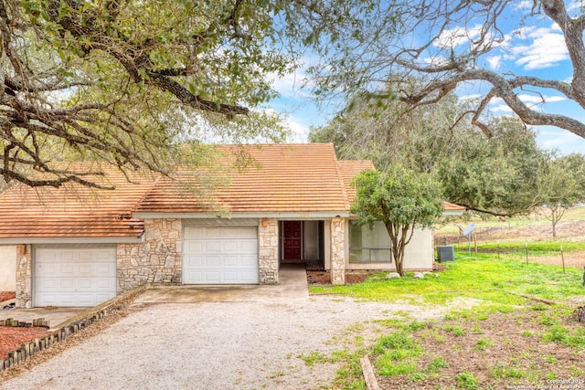 view of front of house with a garage and cooling unit