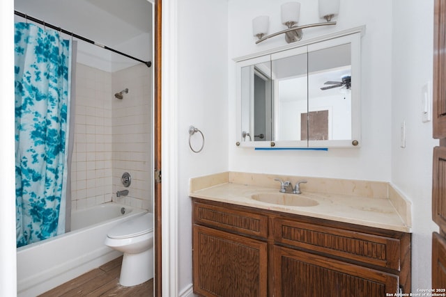 full bathroom featuring toilet, shower / bath combo with shower curtain, ceiling fan, hardwood / wood-style floors, and vanity