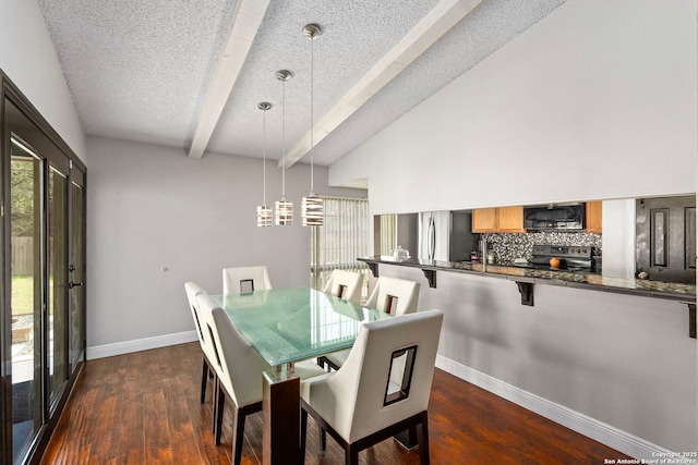 dining room with dark wood-style floors, a textured ceiling, vaulted ceiling with beams, and baseboards