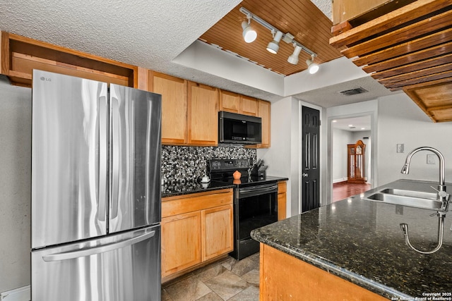 kitchen with visible vents, decorative backsplash, dark stone countertops, black appliances, and a sink