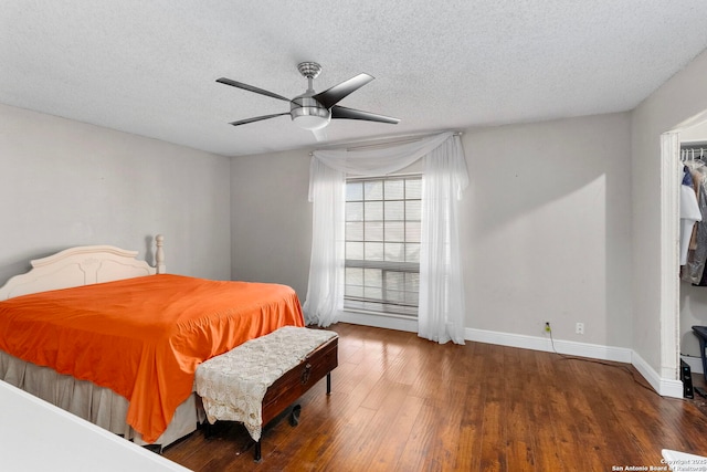 bedroom featuring a textured ceiling, baseboards, and wood finished floors