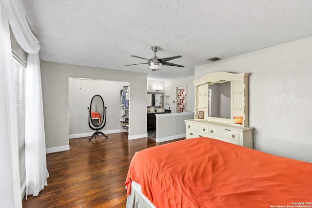 bedroom with baseboards, dark wood-style floors, visible vents, and a textured ceiling