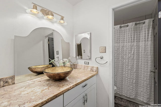 bathroom featuring toilet, vanity, and a shower with shower curtain