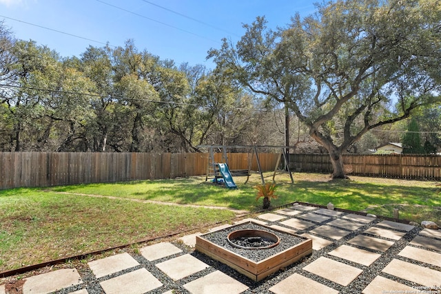 view of yard with a patio, a fenced backyard, and a playground