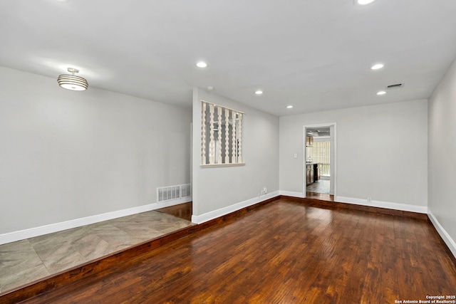 spare room with recessed lighting, visible vents, baseboards, and hardwood / wood-style flooring