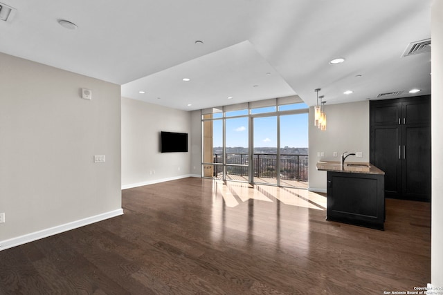 living room featuring dark hardwood / wood-style flooring, floor to ceiling windows, and sink