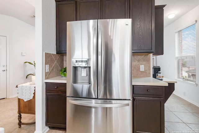 kitchen featuring light tile patterned floors, dark brown cabinetry, and stainless steel refrigerator with ice dispenser