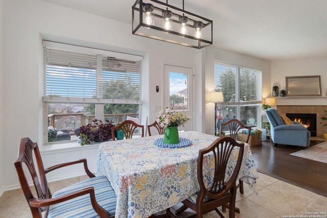 tiled dining area with a tile fireplace and a healthy amount of sunlight