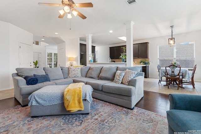 living room featuring ceiling fan, ornate columns, and hardwood / wood-style floors