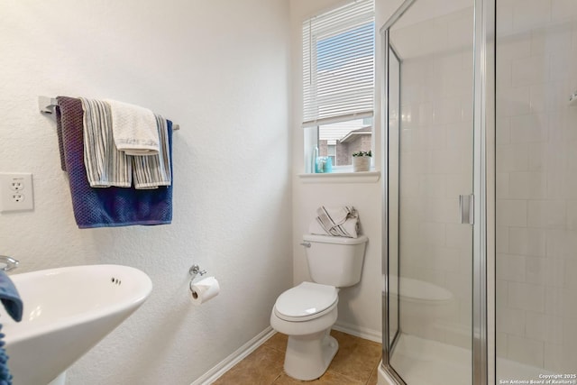bathroom featuring sink, tile patterned flooring, toilet, and a shower with door