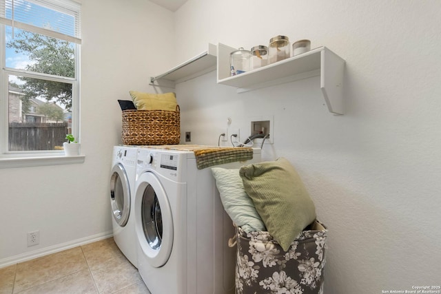 laundry area with washing machine and dryer and light tile patterned floors