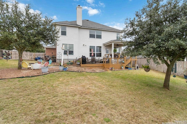back of property featuring a deck, a patio, and a lawn