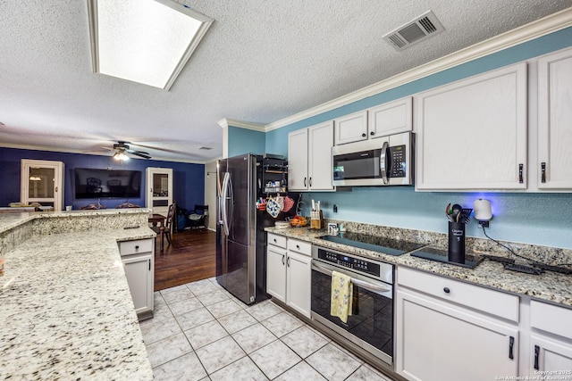 kitchen featuring stainless steel appliances, white cabinetry, light stone countertops, and crown molding