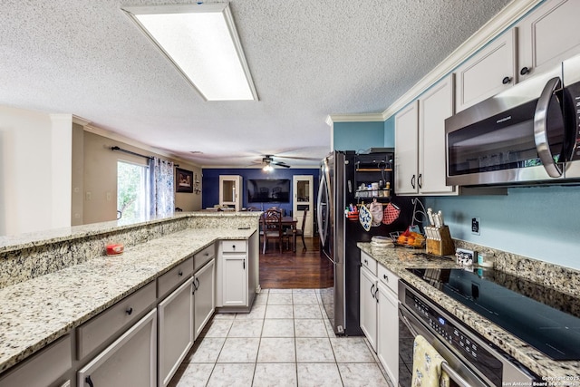 kitchen with stainless steel appliances, light stone counters, ceiling fan, a textured ceiling, and light tile patterned floors