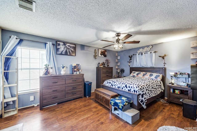 bedroom featuring a textured ceiling, ceiling fan, and dark hardwood / wood-style flooring