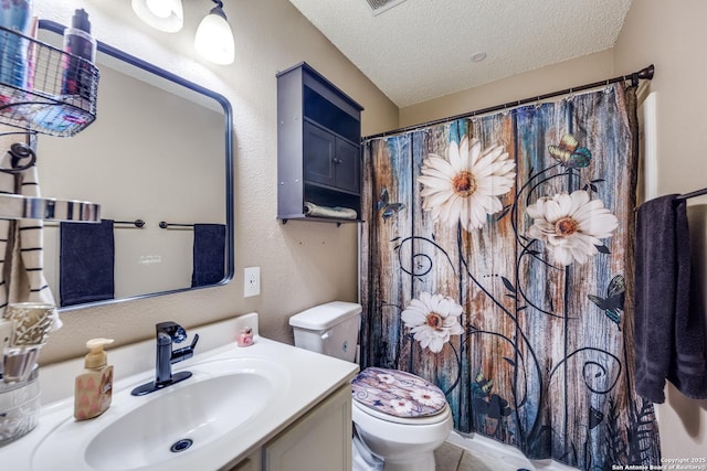 bathroom featuring a textured ceiling, toilet, and vanity