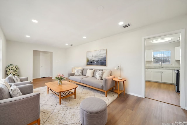 living room with sink and light hardwood / wood-style floors