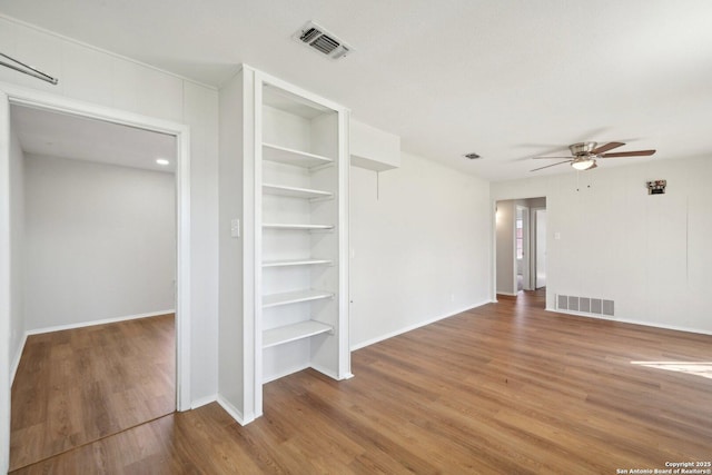 interior space with hardwood / wood-style flooring, ceiling fan, and built in features