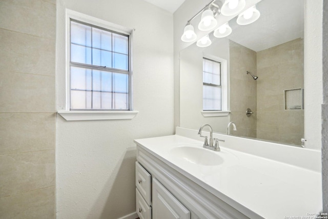 bathroom with vanity and a tile shower