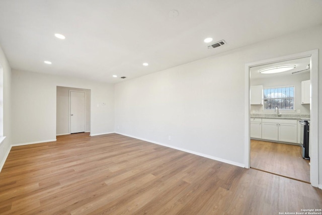 spare room featuring light wood-type flooring and sink