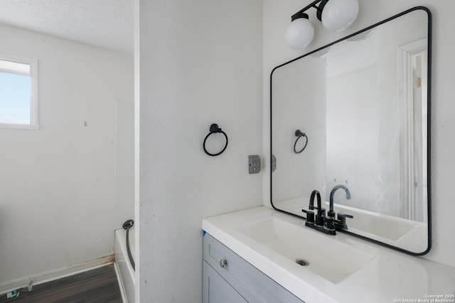 bathroom featuring hardwood / wood-style floors, a textured ceiling, and vanity