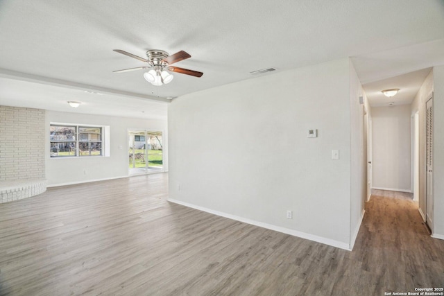 empty room featuring a textured ceiling, hardwood / wood-style floors, and ceiling fan