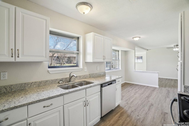 kitchen with light hardwood / wood-style flooring, sink, light stone counters, dishwasher, and white cabinets