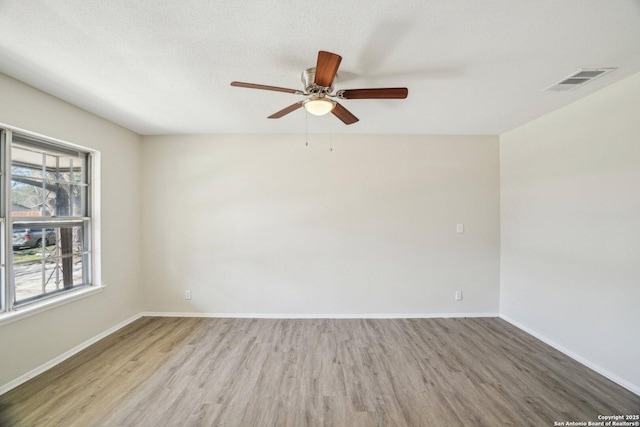 spare room featuring hardwood / wood-style flooring, ceiling fan, and a textured ceiling