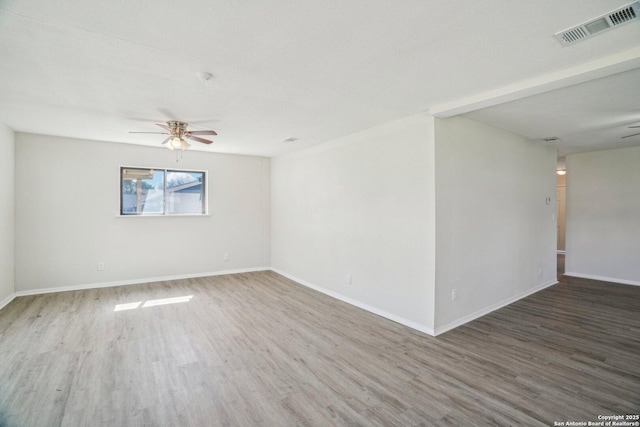 empty room featuring ceiling fan and dark wood-type flooring