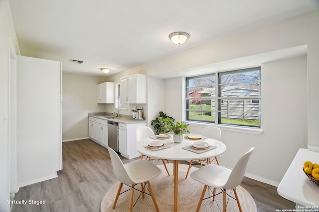 dining space with sink and light hardwood / wood-style floors