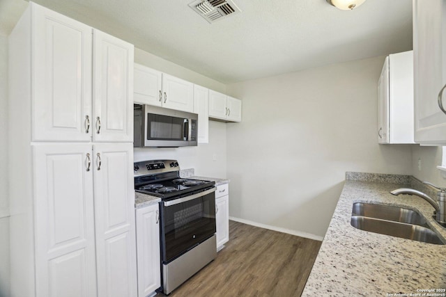 kitchen featuring sink, white cabinets, light stone countertops, and stainless steel appliances