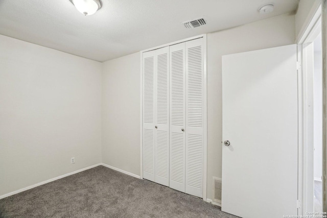 unfurnished bedroom featuring carpet and a closet