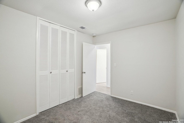 unfurnished bedroom featuring carpet floors, a closet, and a textured ceiling