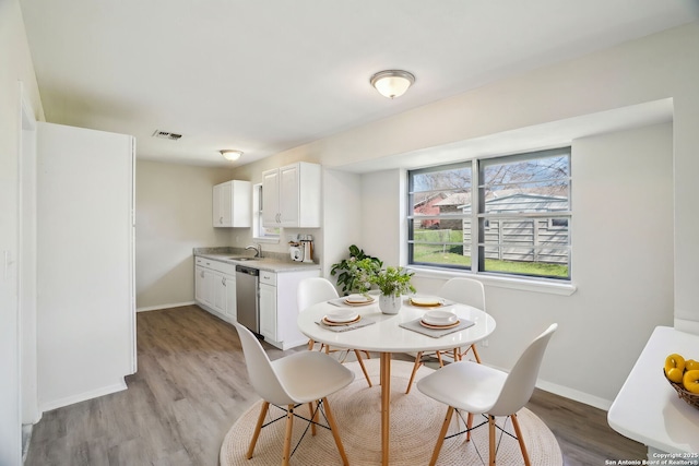 dining space featuring light hardwood / wood-style flooring and sink