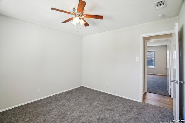 empty room featuring dark carpet and ceiling fan